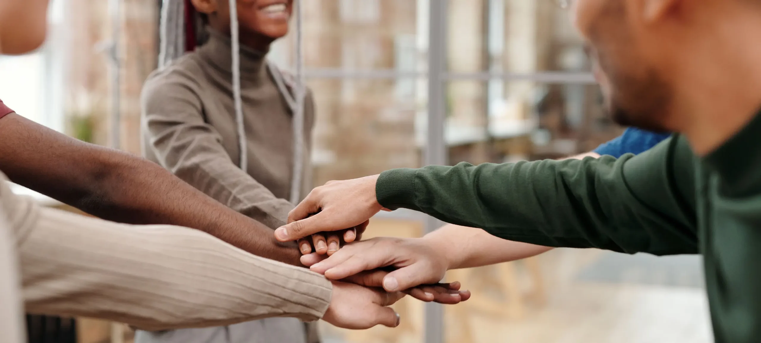 Team members stacking their hands together.